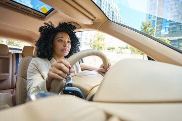 Pretty mixed race woman driving a car