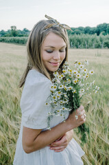 Portrait of a woman in a field with flowers in her hands