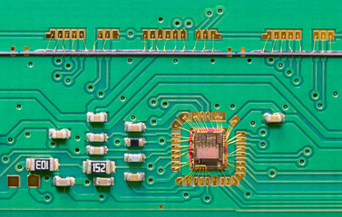 Integrated circuit die wired to green printed board texture with line scan camera. Close-up of chip...