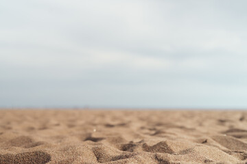 Fototapeta na wymiar Closeup photo of sandy beach with sea and sky on background