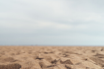 Closeup photo of sandy beach with sea and sky on background