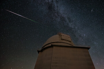 Perseid meteor shower over astronomical observatory