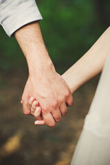 The bride and groom hold each other's hands