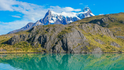 Peaks of Torres seen from Pehoe Lago with turquoise water in Torres del Paine National Park, Patagonia, Chile, at sunny day and blue sky. - obrazy, fototapety, plakaty