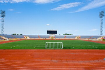 Obraz premium STADIUM - Football field with goal and tablo on blue sky