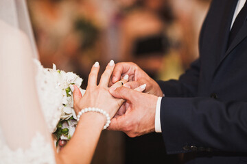 Obraz na płótnie Canvas Bride and groom exchange rings at the wedding ceremony