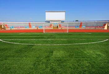 Fototapeta na wymiar STADIUM - Football field with goal and tablo on blue sky