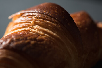Close up of French croissant on a dark background.  - obrazy, fototapety, plakaty