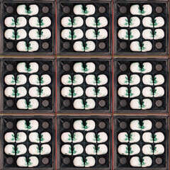 Creative pattern made of skulls in the desserts box.  Dark Love or Halloween concept. Flat lay.