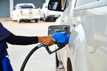 Hand holding the blue diesel nozzle  At the gas station, the concept of oil crisis, expensive oil