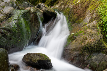 Naklejka na ściany i meble Long exposure of a waterfall on the Hoar Oak Water river at Watersmeet in Exmoor National Park