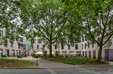 Fototapeta na wymiar Münster, Germany, July 29, 2022: large trees that were preserved in the area of the Stubengasse urban redevelopment