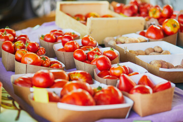 Red ripe tomatoes on market in Cucuron, Provence, France - obrazy, fototapety, plakaty
