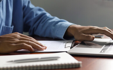 Businessman using laptop to analyze graphs and charts on his desk. Successful work planning