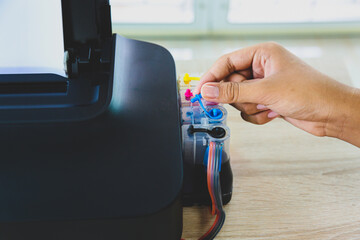 Close up hand pull ink tank lid on printer on the office desk for replace cartridges or refill ink...