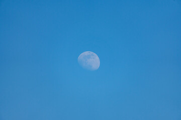Visible moon at day with blue sky