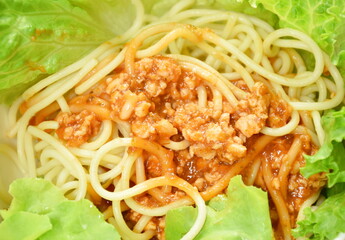 spaghetti dressing fried chop pork and slice tomato in ketchup sauce with vegetableon on bowl