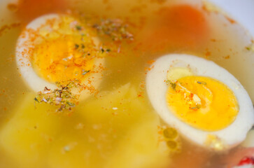 Halves of a boiled egg float in a delicious broth