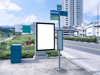 Blank vertical advertising poster banner mockup at empty bus stop shelter by main road, greenery...