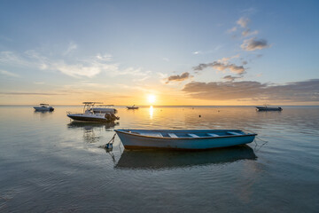 Tranquil sunset at the beach with small fishing boats 