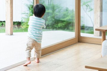 窓を開ける2歳の子供（育児・子育て・危険）