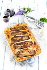 Classic style traditional Greek moussaka served as top view on a classic design skillet on a white wooden table