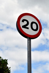 Road sign showing a 20 mph speed limit at the approach to a residential area