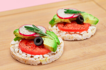 Rice Cake Sandwiches with Avocado, Tomato, Cottage Cheese, Olives and Radish on Bamboo Cutting Board. Easy Breakfast. Diet Food. Quick and Healthy Sandwiches. Crispbread with Tasty Filling