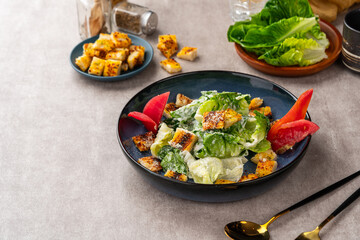 Caesar salad is a green salad of romaine lettuce and croutons dressed with mustard, Parmesan cheese, and garlic bread.