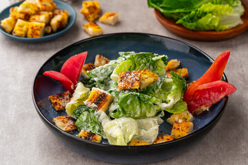 Caesar salad is a green salad of romaine lettuce and croutons dressed with mustard, Parmesan cheese, and garlic bread.