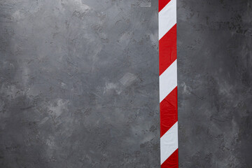 Fototapeta na wymiar Barrier tape red and white at cement floor background. Signal warning tape on concrete wall