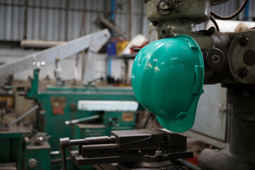 A green helmet is placed on top of the machine. in heavy industry