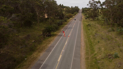 Aerial shot of cars stopped by traffic controller on rural road during construction site