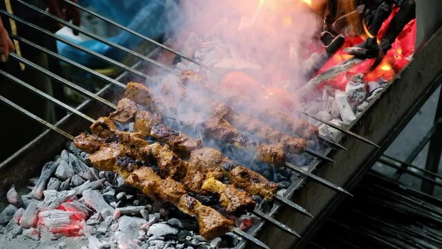 Close-up of kebabs on skewers grilling on brazier. Turkish traditional kebabs grill on coal