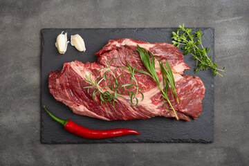 Raw beef steak on concrete table top. Healthy food concept. beef cut and spices for cooking bbq sauce