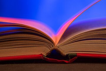 Open book on the table. Education and reading concept. Retro neon light