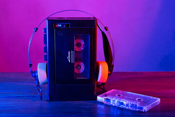 Vintage cassette tape player in neon light. 80s - 90s advertisement style. Disco party nostalgy concept - 520375575