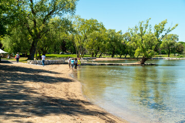 Tourist walking on the Huron Lake Georgian Bay water and greenery at sunny day at Owen Sound town, Ontario, Canada.
