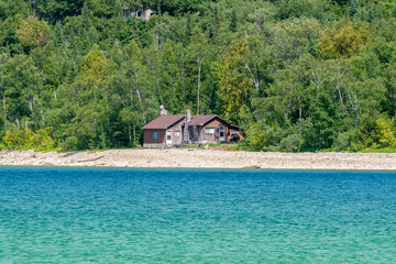 Fototapeta na wymiar Houses cottages or villas at Lake Huron Lion's Head Beach Harbour in Lion's Head Provincial Park Ontario Canada. Isthmus Bay, Lion's Head Point. Cottages for rent and personal leisure.