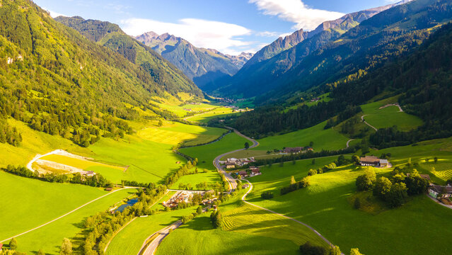 Aerial view of highway road pass in Alpine mountains of Austria. Tyrol village. mountain range river several roads, houses, meadows. Road between Austria and Italy on the border.