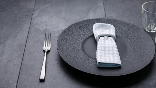 Classic serving tableware on the table, black plate fork and knife.