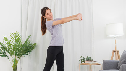 Yoga exercise concept, Asian woman warm up to stretching arms before doing yoga exercise online