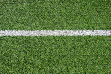 Green synthetic artificial grass football or soccer field with white line and shadow from football...