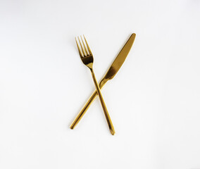 Golden spoon and fork isolated on a white background