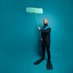 Ocean pollution and environmental protection concept. Diver with mop on blue