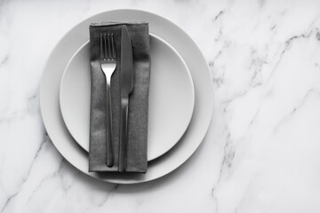 Dining table setting. Two grey plates with silver cutlery on the linen napkin. Minimalism style.