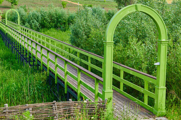 Fototapeta premium Wooden bridge in a park over a pond
