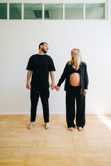 Fototapeta premium Portrait of future mother and father, husband hug pregnant wife. Happy family resting at home 