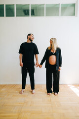 Fototapeta premium Portrait of future mother and father, husband hug pregnant wife. Happy family resting at home 