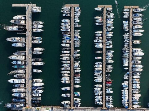 Aerial view of pontoons full of boats and sailboats in the marina. - Powered by Adobe